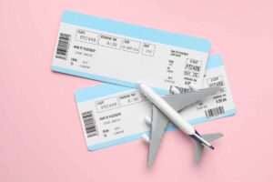biglietti aerei sotto un fermacarte a forma di aeroplano