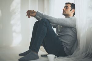 uomo solitario seduto ad una finestra