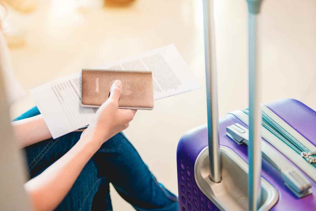 donna in aeroporto con valigia e passapotto