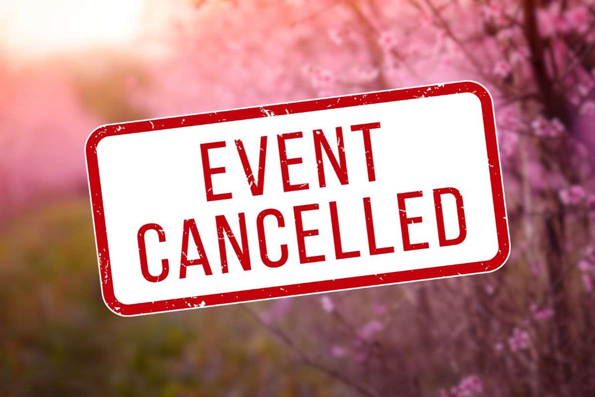 alberi di ciliegio come sfondo e in primo piano scritta 'evento cancellato'
