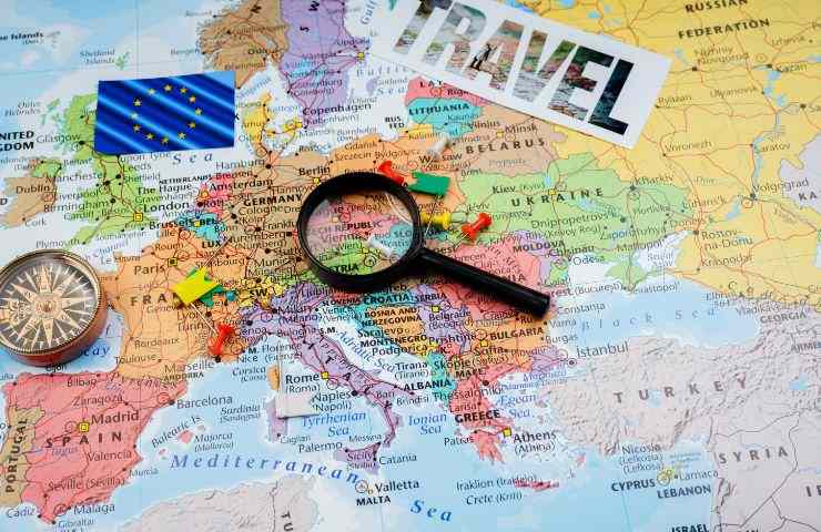 cartina europea, scritta viaggio e lente d'ingrandimento