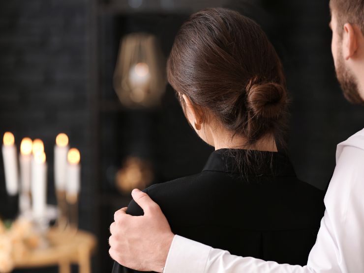 due persone tristi di fronte ad una persona morta