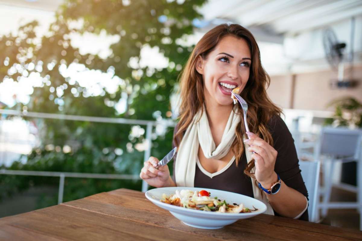 donna che mangia insalata al ristorante