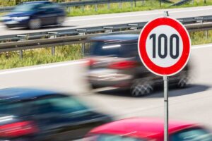 macchine che sfrecciano in strada e limite di velocità