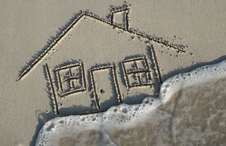 sagoma di casa disegnata sulla spiaggia